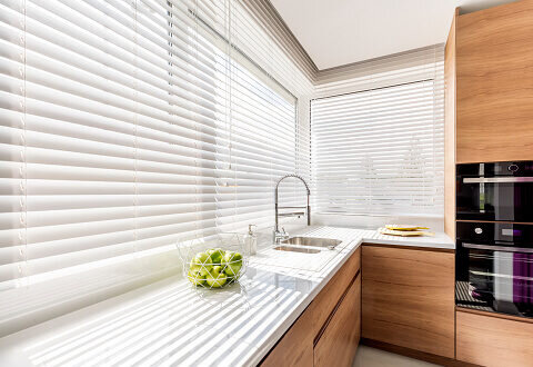 Weiße Innenjalousien am Fenster