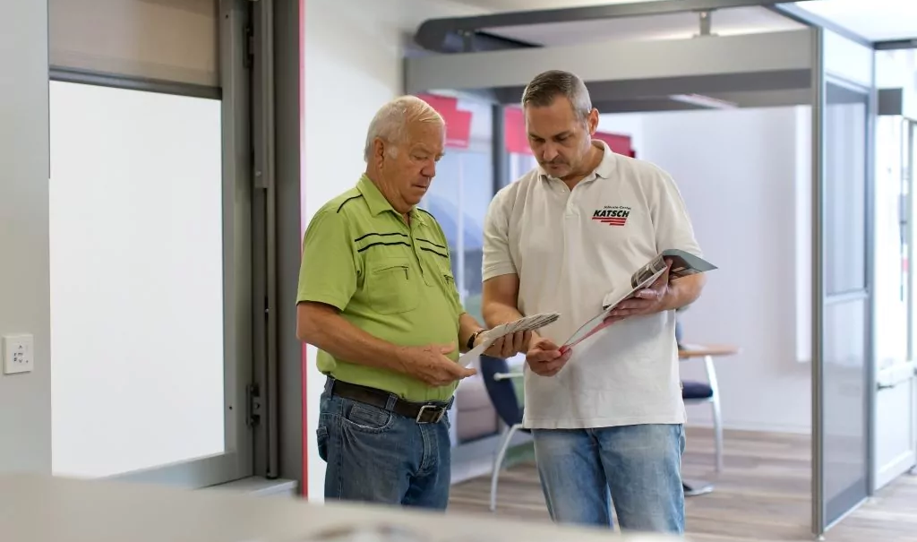 Ein Mitarbeiter des Jalousie-Center Katsch berät einen Kunden zu passenden Modellen in der Produktausstellung des Unternehmens.