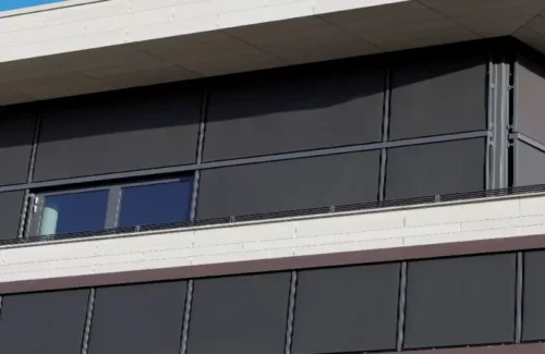 Eine große Fensterfront wird mit durch Somfy Steuerungssysteme angetriebenen Sonnenschutz beschattet.