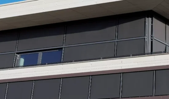 Eine große Fensterfront wird mit durch Somfy Steuerungssysteme angetriebenen Sonnenschutz beschattet.