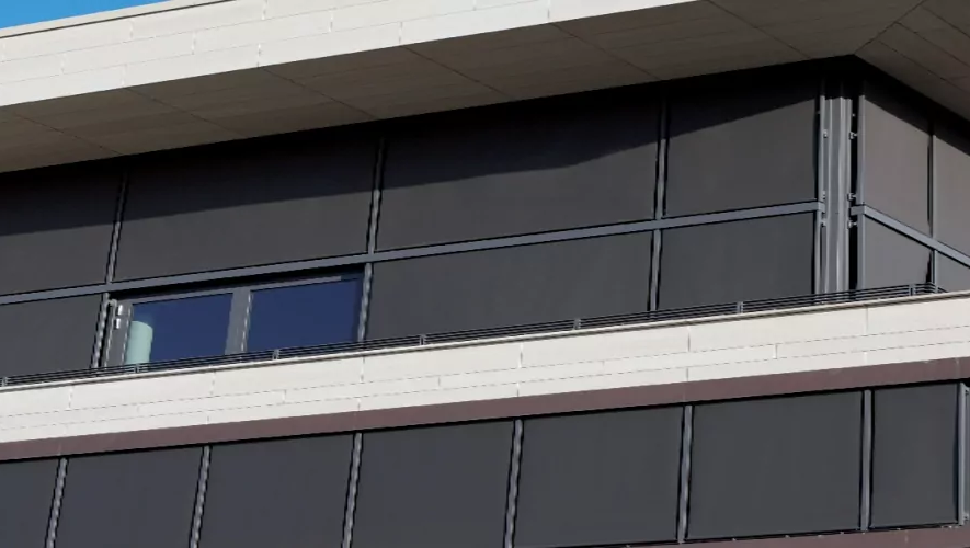 Eine große Fensterfront wird mit durch Somfy Steuerungssysteme angetriebenen Sonnenschutz beschattet.