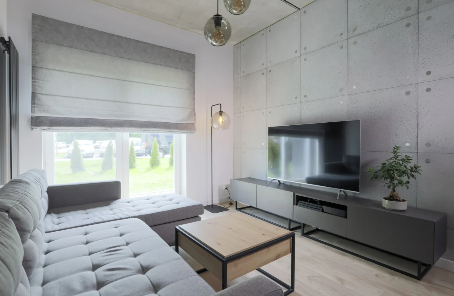 Modernes Wohnzimmer mit grauem Sofa und Flachbildfernseher