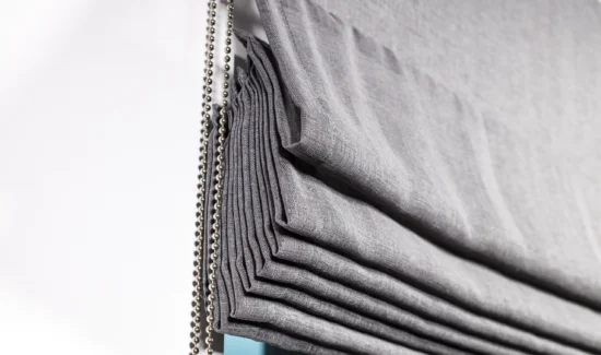 Dunkles Raffrollo mit Raffungen in Nahaufnahme mit Kugelkette