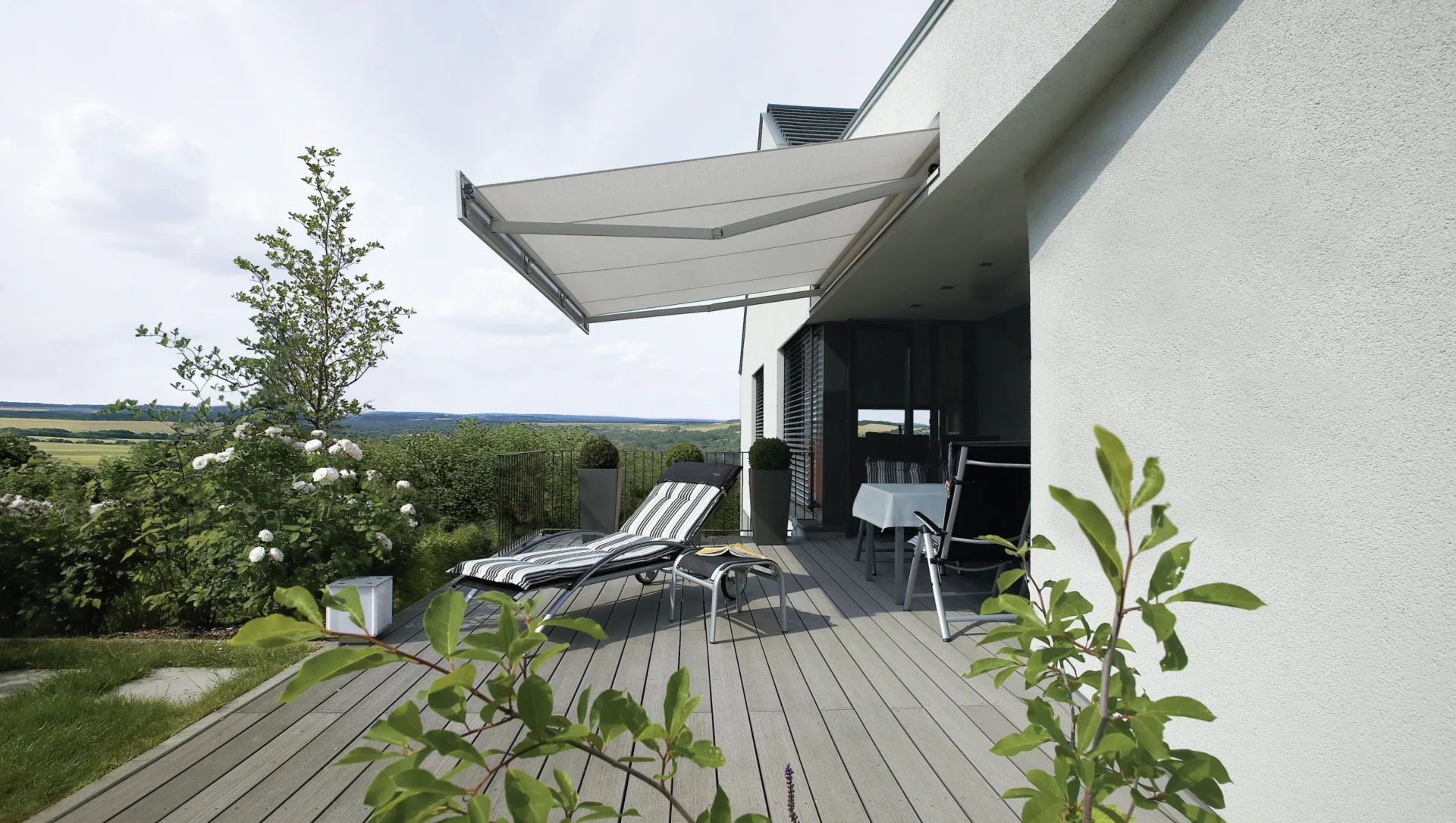 Moderne Terrasse mit Sonnenschutz und Liegestühlen